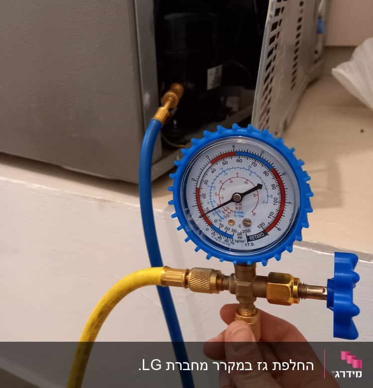 מד לחץ מחובר למקרר עם צינורות כחולים וצהובים